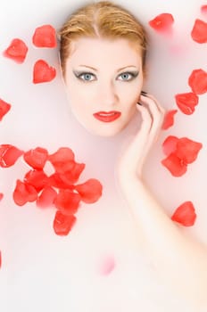 Portrait of a young woman taking a relaxing bath with rose petals
