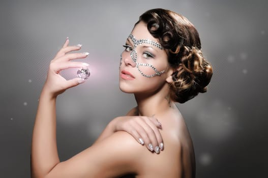 Portrait of a cute lady with diamonds and rhinestone-makeup.