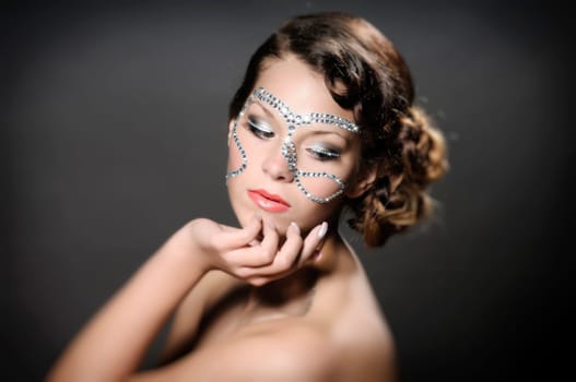 Portrait of a cute lady with diamonds and rhinestone-makeup.