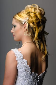 Portrait of a young bride with high hair und white bride dress.