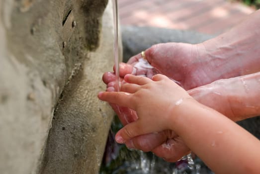 hands of mom and son under the fountain