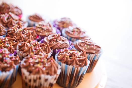 Closeup of chocolate cupcakes with decorative sprinkles on plastic tray