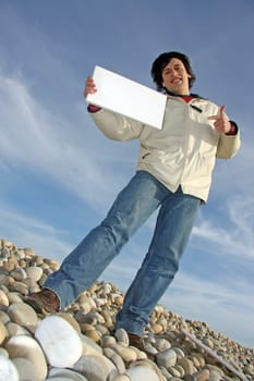 Man with empty card on beach