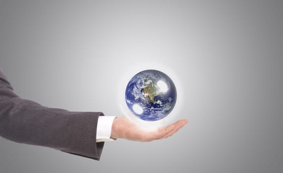 business man with earth globe in his hand, grey background