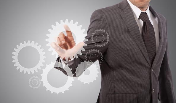 business man touching gear on glass board