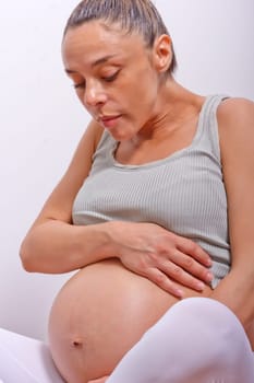 pregnant woman sitting with cross leg and holding her belly