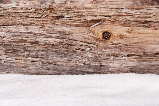 a pice of driftwood and white sand as background with copy space