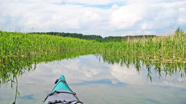 canoe on a river canal surrounded by reed