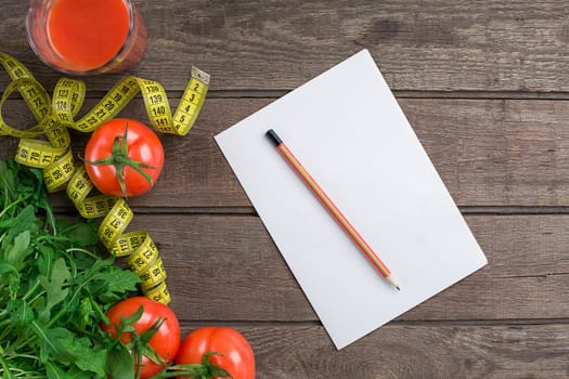 Glass of tomato juice with vegetables and measuring tape on wooden table close-up. Copy space. Top view