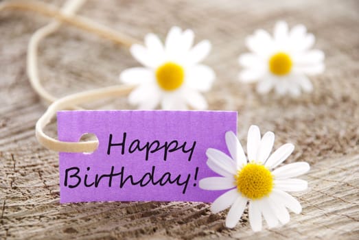 happy birthday written on a purple banner, flowery background