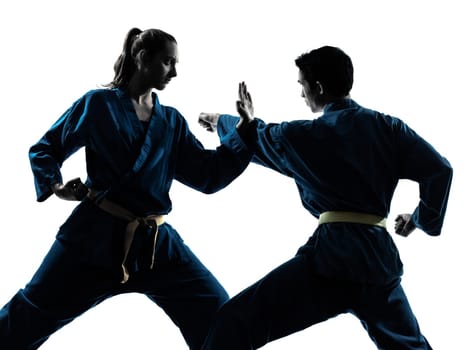 one  man woman couple exercising karate vietvodao martial arts in silhouette studio isolated on white background