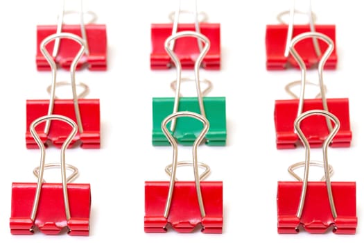 Green paper clip among red  , closeup