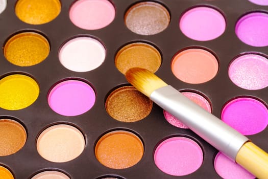Set of multicolored eyeshadows with makeup brush