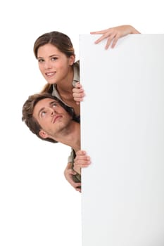 couple behind white panel