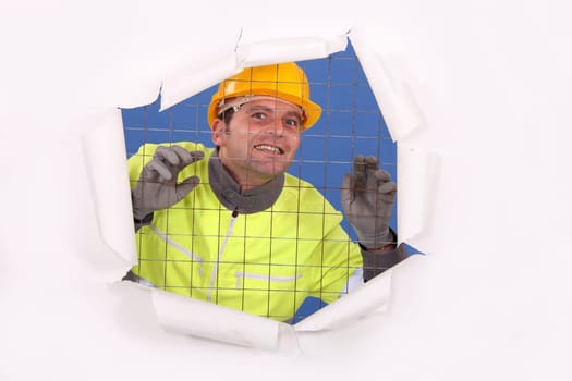 Construction worker behind wire fence