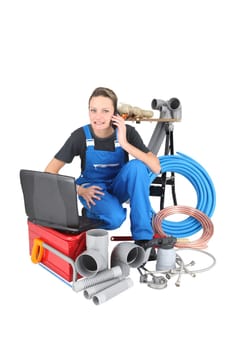Tradeswoman surrounded by building materials and technology