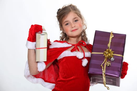 Little girl dressed in festive outfit carrying presents