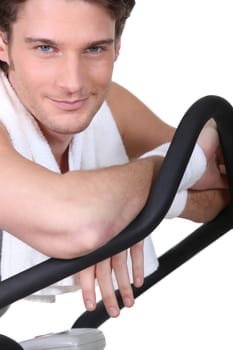 Smiling man sitting on cross trainer