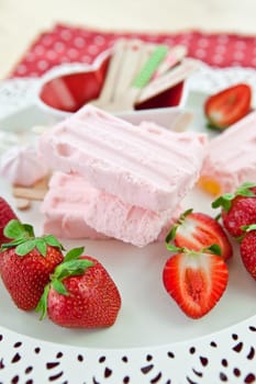 Homemade strawberry popsicles and fresh strawberries