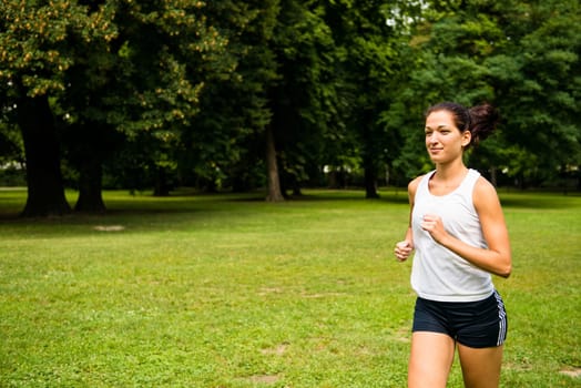 Jogging lifestyle - young beautiful woman running in park
