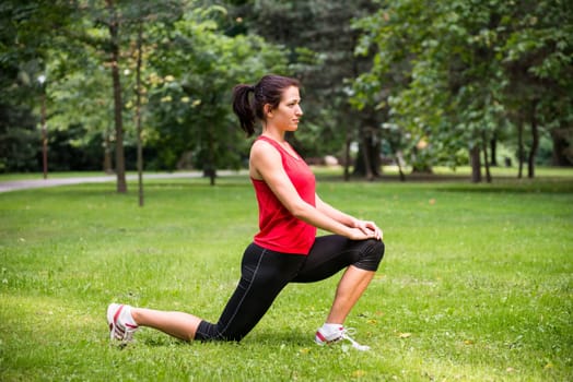 Young sport woman exercising before jogging - outside in nature