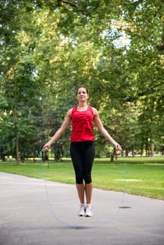 Young fitness woman exercising - jumping with skipping rope