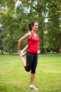 Young sport woman is stretching leg before jogging - outdoor in nature