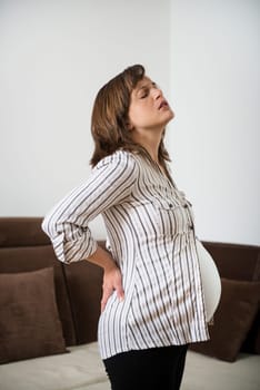 Pregnant woman sitting on fit ball with backache