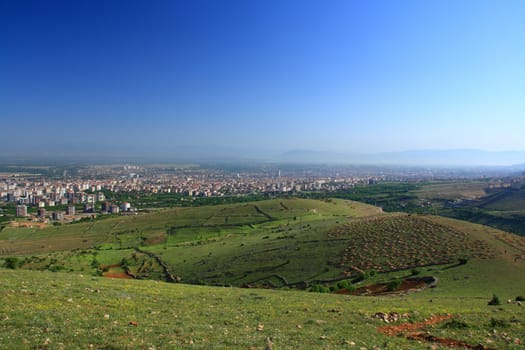 village between hills on spring day with blue sky