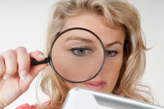 Woman with magnifying glass and digital tablet