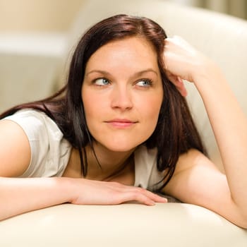 Thinking pensive woman lying in living room on sofa