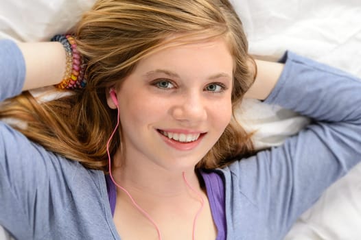 Portrait of relaxing lying young girl listening to music