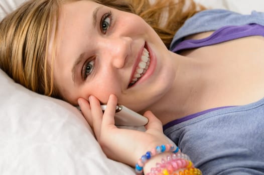 Portrait of a smiling teenager girl talking on her phone