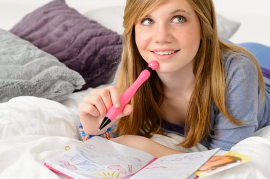 Daydreaming teenager girl writing her journal about a boy