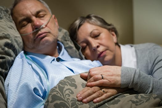 Old couple sleeping together in bed man with nasal cannula