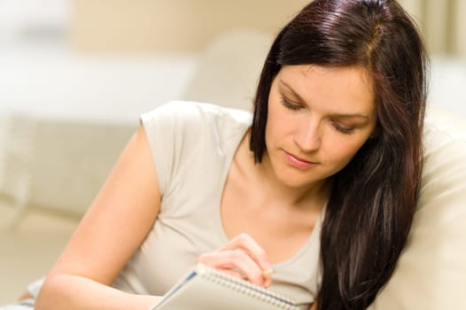 Young woman writing letter to copybook