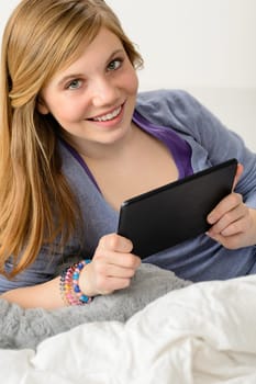 Happy young girl using digital tablet for studying