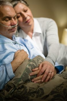 Loving elderly couple sleeping in bed sick husband