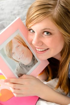 Smiling teenage girl holding a picture of her love