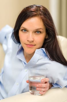 Beautiful woman looking at camera holding glass of water