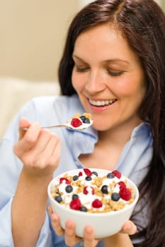 Dieting woman eating healthy cereal with yogurt for breakfast