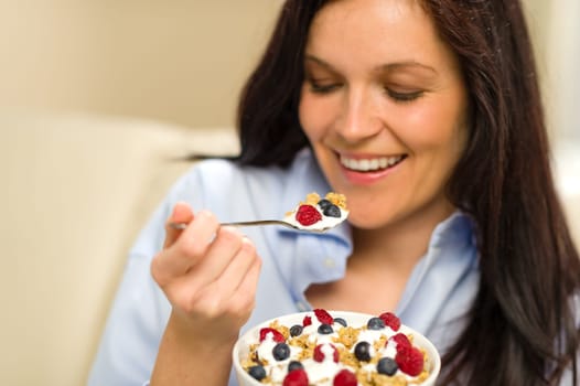 Relaxed woman eating bowl of cereal for breakfast