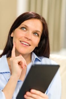 Portrait of pensive cheerful woman holding digital tablet