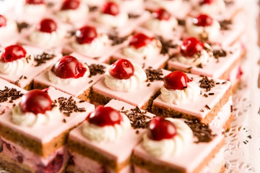 Cream filled cakes with cherry and chocolate topping