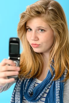 Young girl taking picture of herself with mobile phone