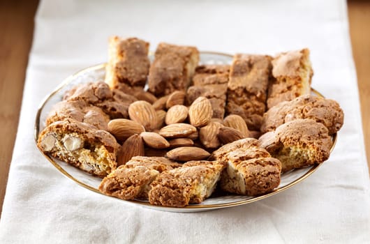 Cantuccini pastries and almond kernels as a close-up on a tablecloth