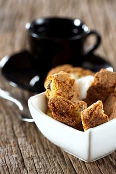Fine cantuccini pastry in a small bowl on a wooden surface