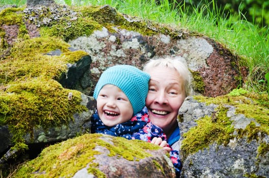 Grandmother with granddaughter hide among stones