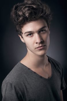 Young handsome man in gray shirt looking at camera