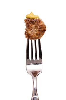 Bited meatball with mustard on a fork